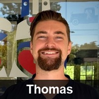 Staff photo of Thomas with the name "Thomas" in white text at the bottom.